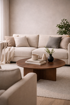 Cozy living room with beige sectional sofa, wooden coffee table, and decorative items.